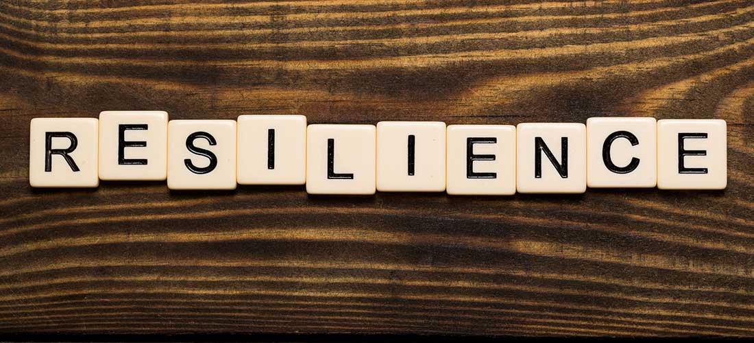 Resilience Spelled Out in Scrabble Letters on a Dark Wooden Table