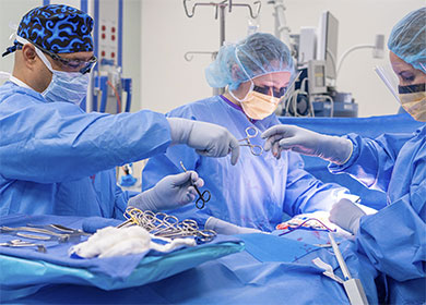 Periop nurses work with a surgeon on a patient.