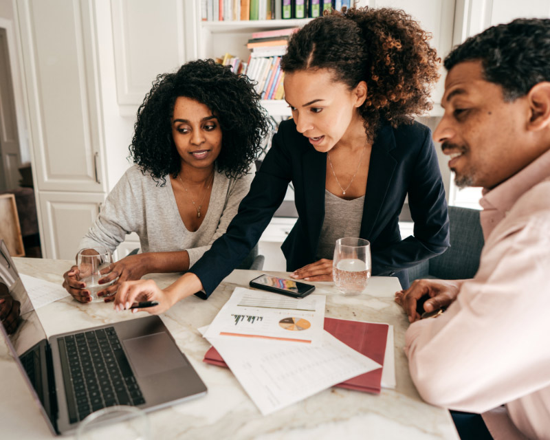 leadership-training Leaders look at laptop together.