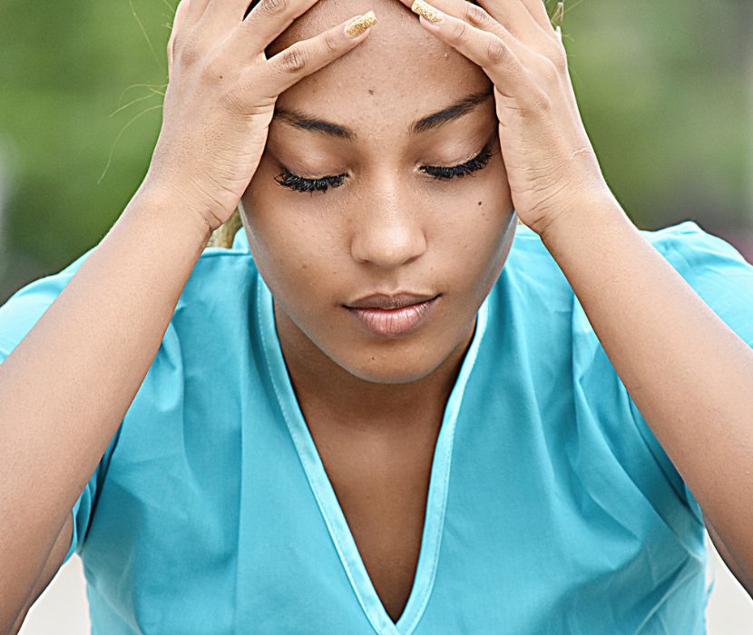 frustrated nurse with head in her hands
