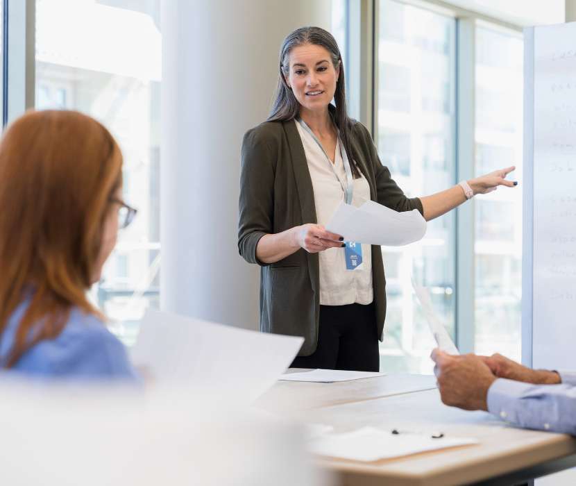 Person speaking to a couple of people in an office space.
