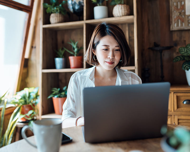 take-action-now-800x640 Person sits at table in house typing on a laptop.