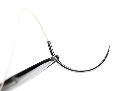 Close up of graspers holding a surgical needle
