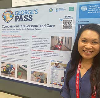 A female poster winner is standing in front of her winning poster.