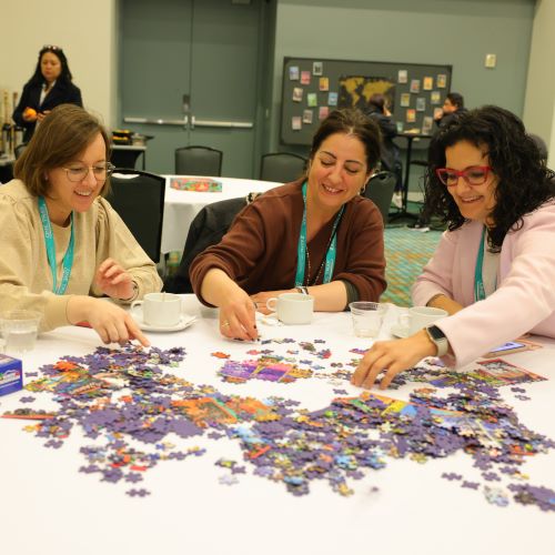 international-lounge Three women work on a puzzle at Expo