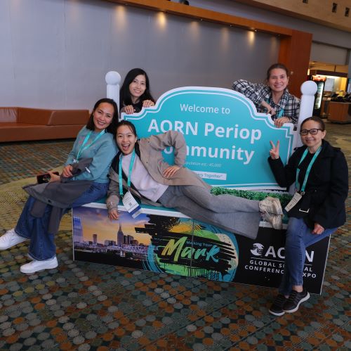 Periop-Community Expo attendees pose in front of sign