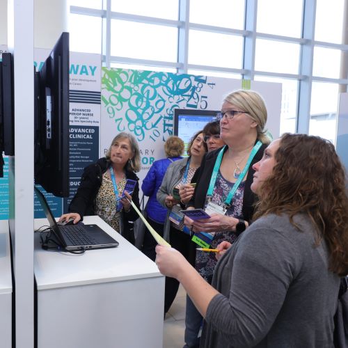 Women-look-at-screen Women look at screen at exhibitor booth