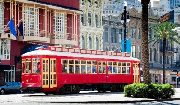 Red and yellow streetcar traveling through a street