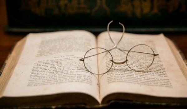 Open book with round eyeglasses resting
