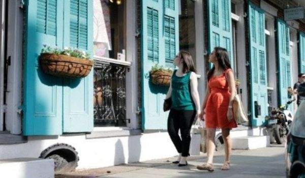 Two people walking past a building